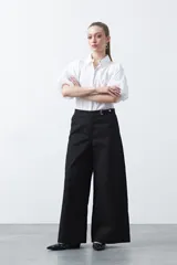 Pantalón wide leg de corte sastrero, color negro, con cintura de tiro medio y diseño de pernera amplia y relajada.