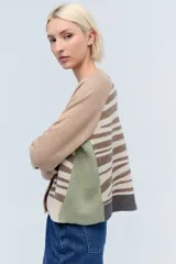 Cardigan de tejido de punto color beige con estampado de cebra en el cuerpo y mangas largas.