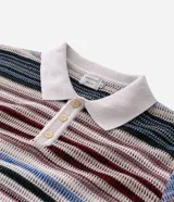 Remera polo de manga corta con diseño de rayas horizontales multicolor. Confeccionada en tejido de punto con trama abierta, cuenta con cuello clásico y cierre frontal de botones.