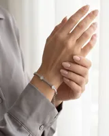 Pulsera de acero con cadena de eslabones finos y cinco dijes circulares engastados con circonias brillantes.