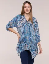 Blusa holgada de poliéster con estampado de arabescos en tonos azules, escote en V con botones frontales, mangas 3/4 y ruedo asimétrico en punta.