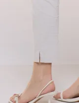 Pantalón color beige de corte entallado y largo cropped, confeccionado en tejido de punto con elasticidad técnica. Cuenta con pretina ancha y plana, bolsillos simulados al frente y bolsillos tipo ojal en la parte posterior.