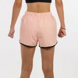 Short deportivo para mujer, color rosa pálido, con cintura elástica fruncida y ribetes negros en los bordes. Presenta un pequeño logo de Diadora en la parte inferior derecha.