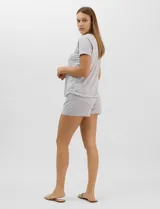 Pijama de dos piezas confeccionado en tejido soft con estampado animal print gris y blanco. Incluye una remera de manga corta con escote en V, detalle plisado en el frente y aplique de puntilla, y un short con cintura elastizada.