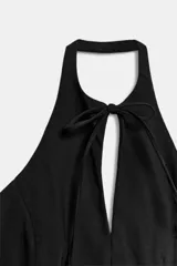 Top de cuello halter con hombros descubiertos, diseño con abertura frontal y cierre mediante lazadas. Presenta un bolsillo pequeño tipo ojal en el frente.