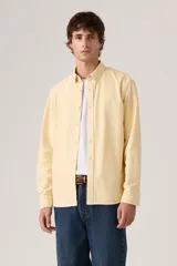Camisa de manga larga color amarillo claro con cierre frontal de botones, cuello camisero y calce clásico.