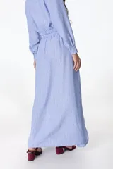 Falda larga celeste con finas rayas verticales blancas, corte evasé y detalle de nudo drapeado en la cintura.