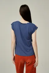 Blusa de poliéster sin mangas, con cuello en V y estampado abstracto multicolor en tonos beige, marrón, negro y naranja.
