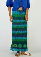 Pollera larga tejida a crochet con diseño de rayas horizontales en tonos naranja, fucsia y morado.