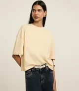 Remera color crema de corte cuadrado y mangas cortas, confeccionada en algodón.