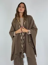 Ruana marrón con detalle de trenza frontal y terminación con flecos.