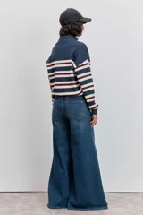 Sweater de punto con diseño a rayas horizontales en azul marino, blanco y bordó. Presenta cuello alto con cierre de botones a presión, mangas largas con puños acanalados y un pequeño bordado en el pecho.