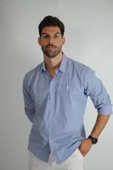 Camisa de manga larga con estampado de rayas verticales en tonos azul y blanco, cuello clásico y cierre frontal con botones.