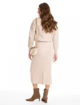 Falda midi de tejido con lurex, color beige, con pretina ancha elastizada y tajo en el ruedo trasero.