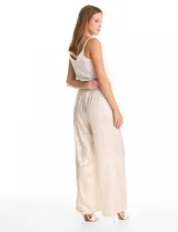 Pantalón de corte wide leg en tejido laminado metalizado color gris. Presenta pretina ancha elastizada con lazo de ajuste y bolsillos delanteros.