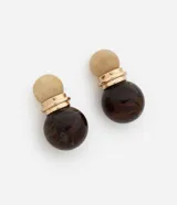 Aros tipo caravana con diseño de doble esfera de resina en tonos beige y marrón, unidos por una pieza metálica dorada. Cierre tipo perno.