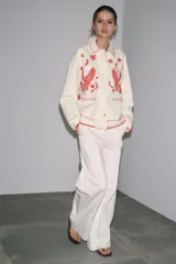 Sobrecamisa color crudo de Zara Woman Collection, con cuello solapa y manga larga. Tiene bolsillos de parche en el delantero y bordados combinados a contraste en color rojo. Cierre frontal con botones a presión ocultos.