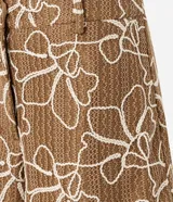 Short color marrón con estampado abstracto en blanco, texturizado, con trabillas en la cintura y cierre tradicional.