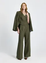 Chaleco verde oliva de lino con corte entallado, escote en V, cierre frontal con botones y pespuntes.