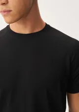 Camiseta deportiva negra de manga corta y cuello redondo, con corte regular y confeccionada en tejido técnico transpirable.