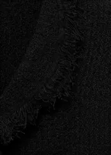 Top de tweed negro con cuello en V, diseño cruzado y terminaciones deshilachadas. Presenta un corte entallado sin mangas y detalle fruncido en la parte frontal.