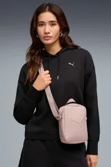 Morral Puma Buzz Portable color rosa viejo con correa ajustable y logo de la marca en relieve en el frente.