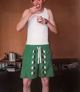 Short de baño verde con estampado de símbolos de yin y yang en blanco y negro. Tiene cintura elástica ajustable con cordón, bolsillos laterales y traseros, y logo bordado.