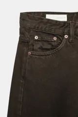Jeans de tiro medio con diseño wide leg y pernera ancha, estilo de cinco bolsillos, cierre frontal con cremallera y botón metálico.