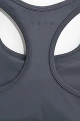 Top deportivo gris oscuro de tejido funcional con tecnología SoftMove™ y DryMove™, con breteles anchos, escote redondo, espalda nadadora y elástico revestido en el bajo.