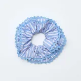 Coletero para el cabello de tela a rayas blancas y azules, con borde decorativo de puntilla en tono azul.