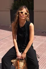 Blusa blanca con lunares negros, cruzada y atada en la cintura.