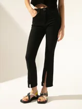 Jeans cropped negro de tiro medio confeccionado en denim de algodón con elastizado sutil. Posee un tajo en la botamanga que permite lucir el calzado, modificando su calce a semi-bootcut.