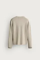 Camiseta relaxed fit de punto negro tejido en hilatura de algodón, con cuello redondo, cierre frontal de botonadura y manga larga con acabado en rib.