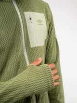 Campera de entrenamiento Umbro con capucha, cierre frontal completo y bolsillo en el pecho de nylon con cierre. Presenta una textura de tejido en relieve y logo de la marca estampado en el bolsillo.