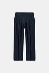 Pantalón de tiro alto color azul marino, de corte recto, con bolsillos delanteros y cierre frontal con cremallera y botón.