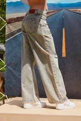 Jean de corte oversize con tiro medio-alto, confeccionado en denim de algodón con lavado tipo ice wash en tono grisáceo. Presenta diseño de cinco bolsillos, cierre frontal y etiqueta de cuero en la parte posterior de la cintura.