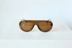 Lentes de sol con armazón de policarbonato color marrón traslúcido y diseño envolvente de una sola pieza.