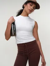 Musculosa básica blanca de corte ajustado y cuello redondo al cuerpo, confeccionada en algodón elastizado.