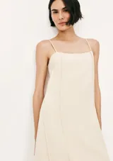 Vestido midi de corte recto y escote cuadrado, con tirantes finos y costuras verticales decorativas a lo largo de la prenda. Color bordó.