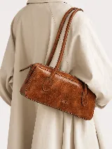 Cartera de cuero tipo baguette de Sagali, con formato alargado, acabado con efecto vintage y dos asas largas para llevar al hombro. Cuenta con cierre superior.