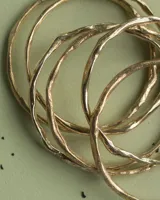 Pulsera rígida de bronce y alpaca, adaptable a muñecas de 13 a 15 cm.