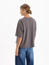 Remera de algodón color gris con estampa gráfica frontal de estilo anime que representa un mercado con un conejo. Presenta un corte amplio, cuello redondo y mangas cortas.