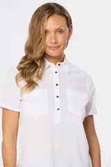 Camisa de lino de manga corta con cuello camisero, cierre frontal de medio botón con botones metálicos personalizados y dos bolsillos en el pecho.