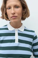 Remera de manga larga con diseño de rayas horizontales en tonos verde inglés y celeste, con cuello polo en color blanco y cierre frontal parcial con botones.