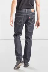 Jean de corte slim fit, color azul oscuro con costuras en contraste. Presenta diseño de cinco bolsillos, cierre frontal con cremallera y botón metálico.