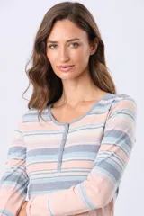 Remera de manga larga con estampado de rayas horizontales en tonos rosados, beige y verde. Presenta un escote redondo con una pequeña abertura frontal con botones y aberturas laterales en el ruedo.