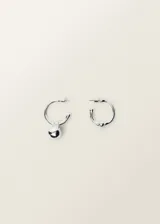 Par de aros tipo argolla plateados, uno con dije colgante en forma de gota y otro con una bolita soldada al aro.