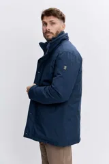 Cazadora azul marino con capucha, cierre frontal con cremallera y botones a presión, bolsillos laterales y diseño acolchado.