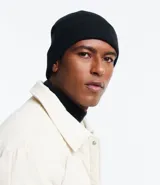 Gorro de tejido de punto color lila, estilo beanie con borde doblado y etiqueta frontal.