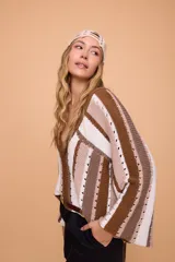 Sweater tejido a crochet con rayas horizontales en tonos marrón, beige y blanco. Tiene escote en V y mangas largas acampanadas.